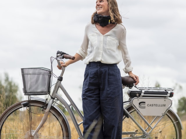 Person standing with a bike with the Castellum logo.