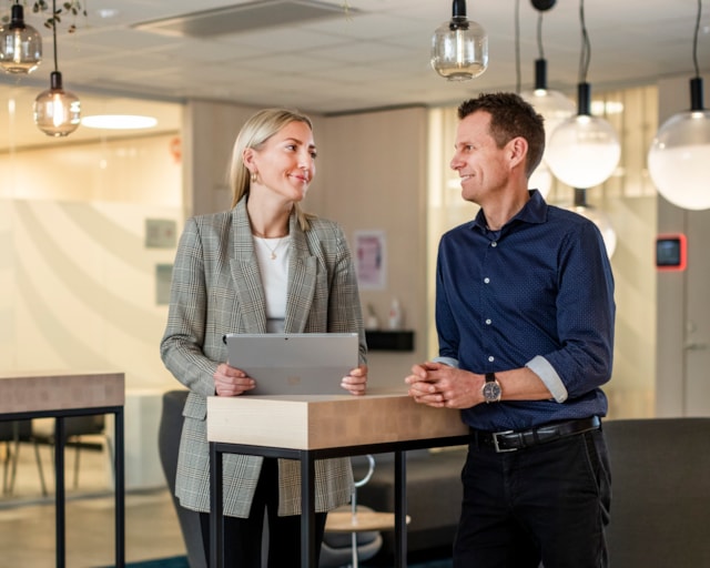 Two people standing by a table.